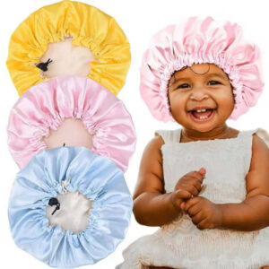 Baby with pink satin bonnet and three other bonnets in yellow, pink, and blue on a white background.